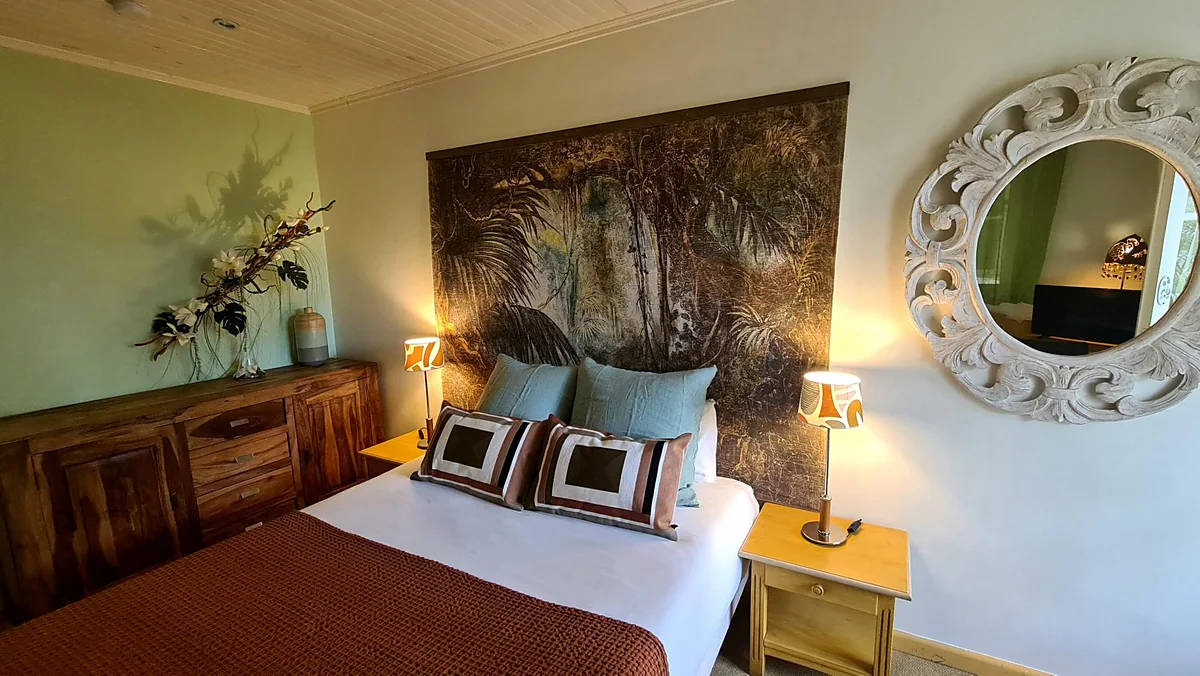 Une chambre de la case, son grand tableau et son miroir rond