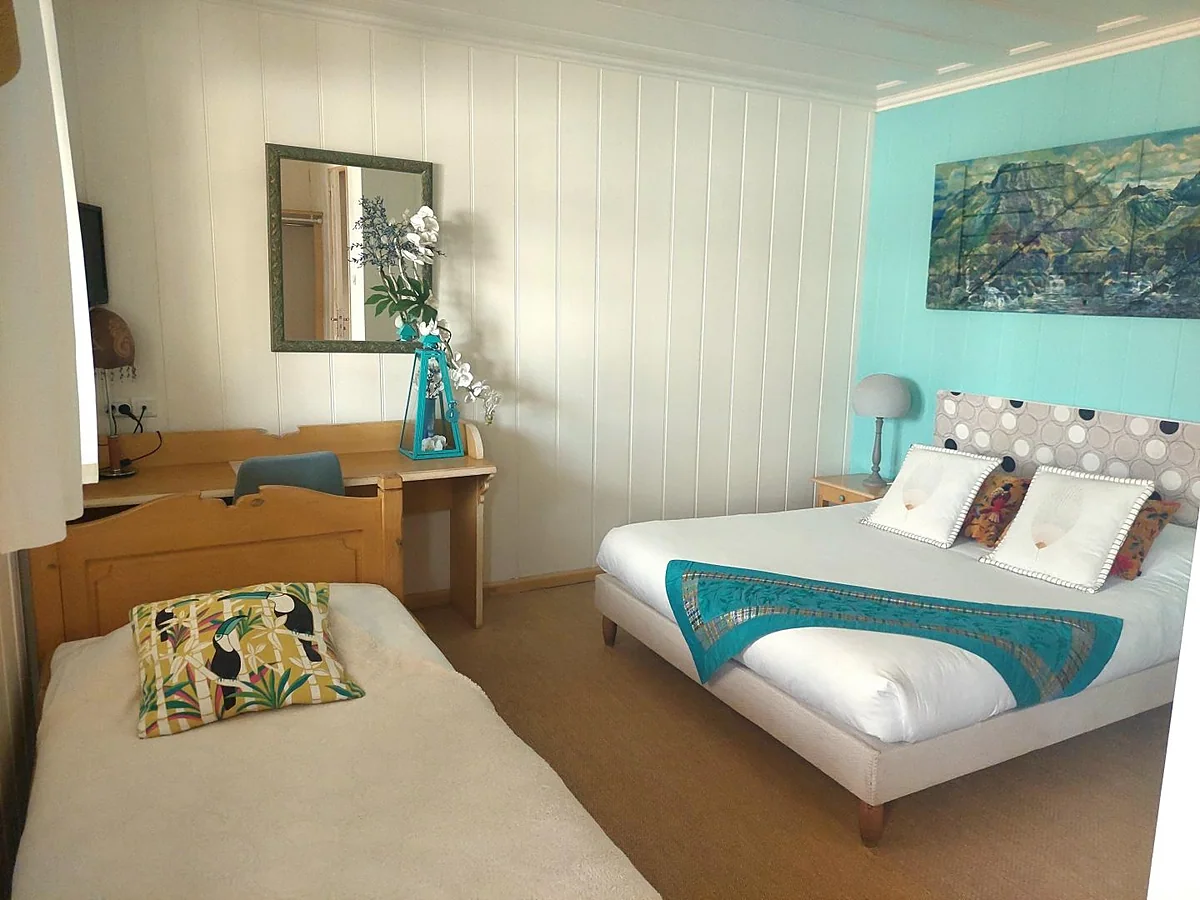 Une chambre avec un grand lit et un lit simple
