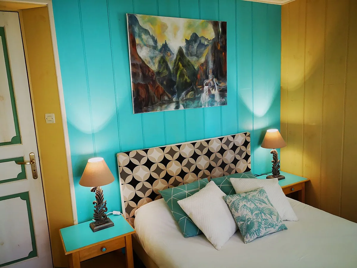 Une chambre de la case aux murs turquoise, et son tableau de Cilaos