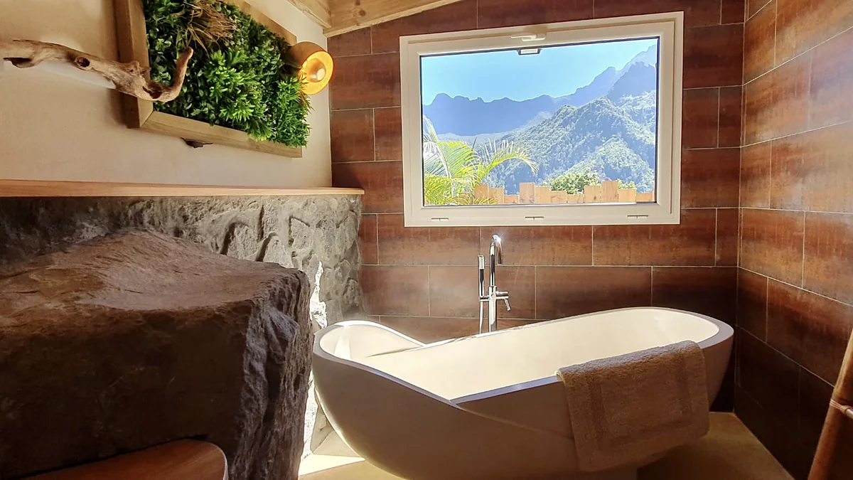 La baignoire en pierre et la fenêtre ouverte sur les montagnes