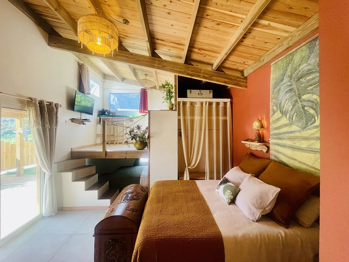 La chambre du lodge sous sa charpente en bois clair